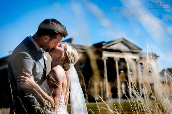 A bride and groom kiss outside of Leigh Court, a wedding venue in Bristol