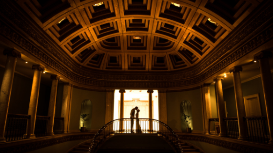 A silhouette of a bride and groom dancing on the Great Hall balcony at Leigh Court