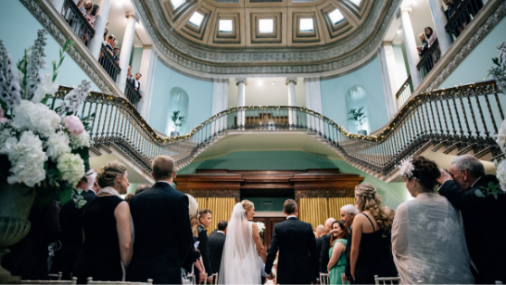 A bride and groom enter the Great Hall for their wedding ceremony at Leigh Court